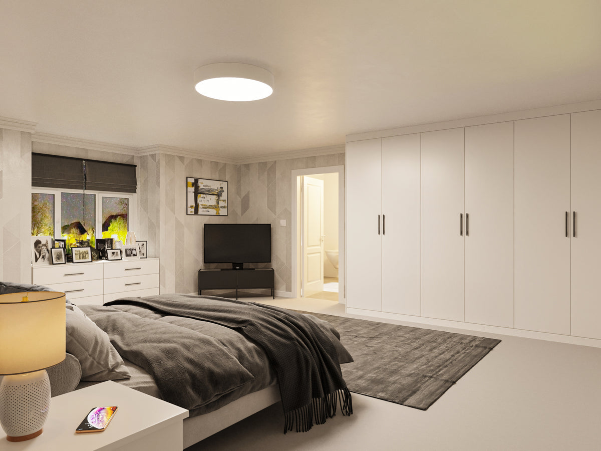 White fitted wardrobe opposite a bed