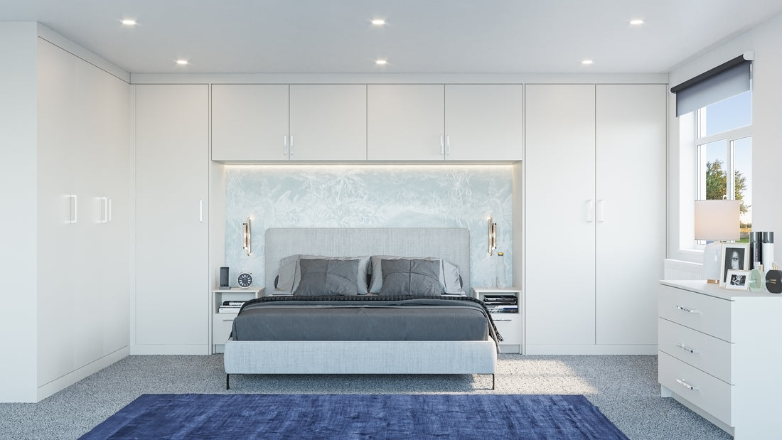 Light-grey fitted wardrobes and overhead storage around a bed