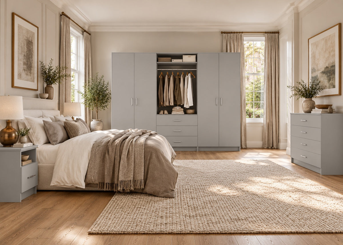 Matt light grey wardrobe, bedside table and chest of drawers in a luxurious bedroom with linen bedding and warm natural light