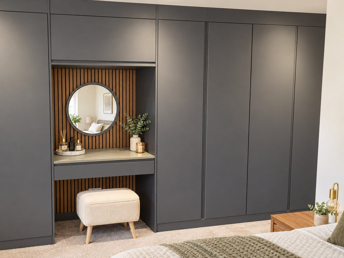 Graphite handleless fitted wardrobes with oak slatted dressing-table niche and round mirror