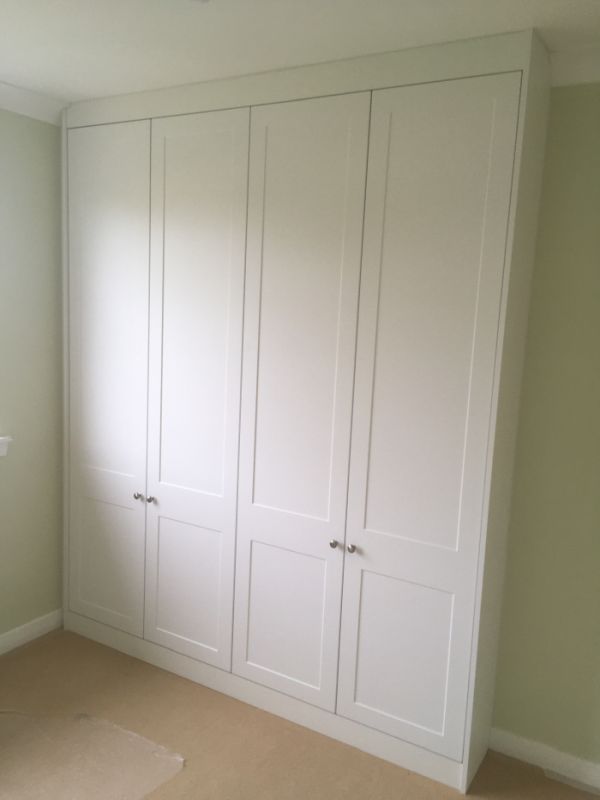 White fitted wardrobe in a small bedroom